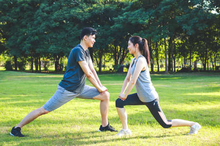 Asian male and female couple Exercise in the outdoor park in the morning. They are healthy, smiling and happy. fitness concept, health careの写真素材