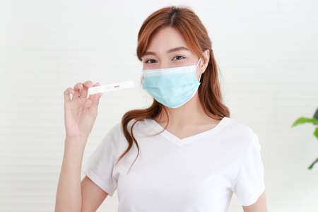 à¸ºbeautiful asian woman She was wearing a blue mask. She is sick with the flu, stays at home and...