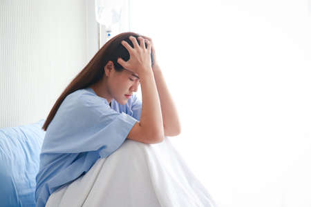 female patient being treated in hospital She sat stressed on her bed in the hospital room. Concept of medical services in hospitals. health insurance. copy spaceの写真素材