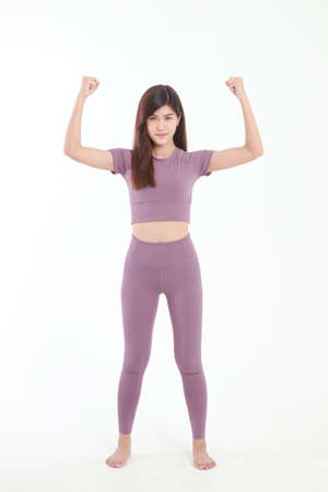 Beautiful Asian woman with good figure Wearing purple workout clothes standing on a white background. fitness concept Weight loss, healthy health care.の写真素材