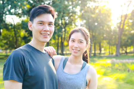 Asian male and female couple Exercise in the outdoor park in the morning. They are healthy, smiling and happy. fitness concept, health careの写真素材