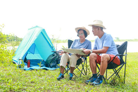 Two Asian elderly couples take a nature tour. Camping and enjoying the beautiful natural scenery. The concept of natural tourism in retirement age.の写真素材