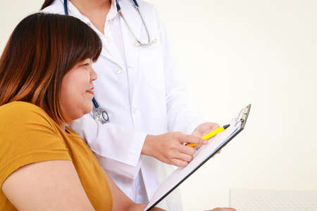 Female doctors perform treatment and examine symptoms of obese female patients. At risk of obesity and diabetes. Weight loss concept For good healthの写真素材