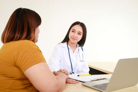 Female doctors perform treatment and examine symptoms of obese female patients. At risk of obesity and diabetes. Weight loss concept For good healthの写真素材
