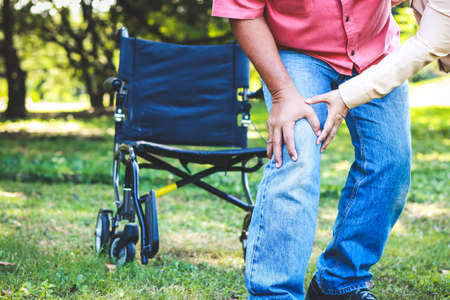 an elderly man in a wheelchair relaxing in the garden He tried to get up and walked, and he had severe knee pain. The concept of caring for osteoarthritis patients.の写真素材