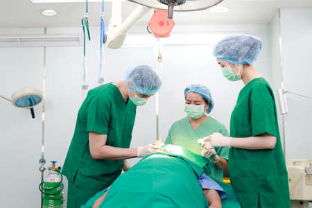 Asian professional surgeon team Operate on a patient lying on a bed in an operating room in a hospital. medical concept Nose surgery. cosmetic surgery.の写真素材