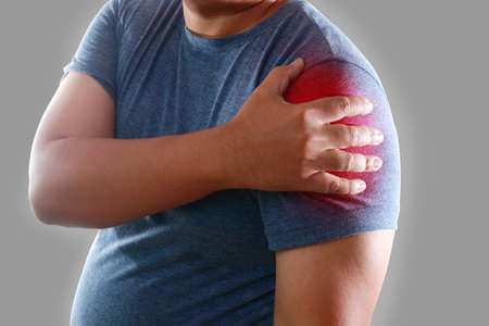 Fat Asian men have shoulder pain caused by muscle inflammation or a torn ligament. Concept of obesity and musculoskeletal disease. Neck and shoulder pain, office syndrome. Clipping Pathの写真素材