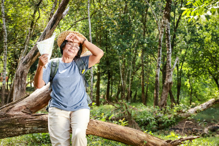 Asian elderly women trekking to travel Feeling tired and hot. Tourism concept of the elderly in retirement age. health care and exercise. copy spaceの写真素材