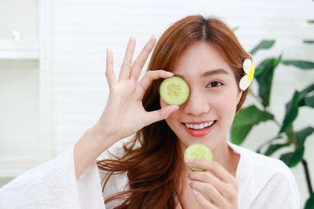 Beautiful Asian girl doing spa at home face mask with cucumber Make your face clear without acne, reduce oiliness on the face, nourish the skin to be smooth and soft. beauty conceptの写真素材