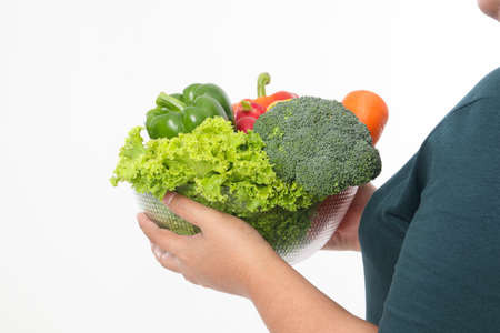 Fat woman holding a cup filled with various kinds of organic vegetables. Eat to lose weight. health care concept, eat healthy food. white backgroundの写真素材