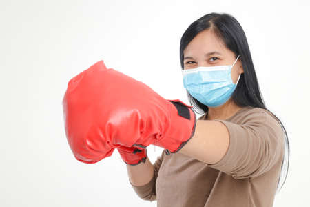 Fat Asian woman wearing a mask and wearing red boxing gloves.の写真素材