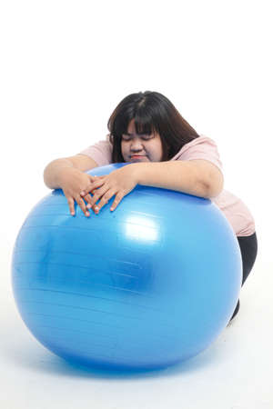 fat woman tired from exercise She was leaning on a blue yoga ball. White background. Weight loss exercise concept. health careの写真素材