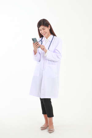 Asian female doctor holding a black smartphone online to talk to a patient to check for symptoms of illness. Medical service conceptの写真素材