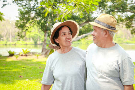 Asian elderly couple Take a vacation in the park. Enjoy life after retirement. The concept of health for the elderly. copy spaceの写真素材