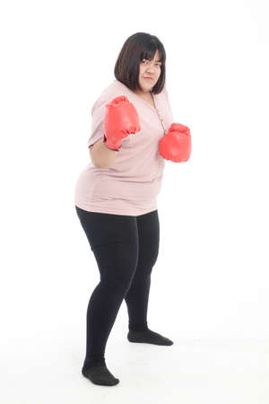 Fat Asian woman wearing red boxing gloves exercising on white background. Concept of exercise, weight loss, health care.の写真素材