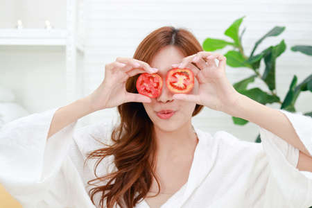 Beautiful Asian woman doing spa at home Use tomatoes to moisturize your face. Keep your skin fresh. beauty concept Natural health care. clear face maskの写真素材