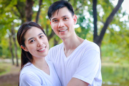 Asian couple wearing white shirts Happy smiling in the park. Family concept. health care. outdoor exerciseの写真素材