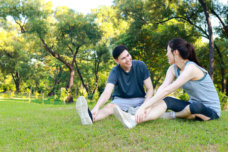 Asian couple exercising together in the park in the morning They are strong and healthy. outdoor...