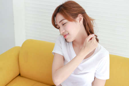 Asian women have shoulder pain, neck pain. Concept of hospital and health care. Chronic shoulder pain. office syndromeの写真素材