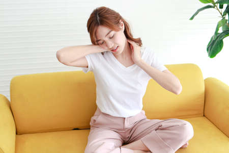 Asian women have shoulder pain, neck pain. Concept of hospital and health care. Chronic shoulder pain. office syndromeの写真素材