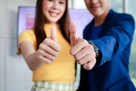 The new generation of Asian business groups give thumbs up for liking. Entrepreneurial concept. Startup business of the new era. working age with health careの写真素材