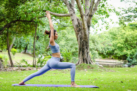 Asian woman exercising outdoors in the garden She is doing stretching yoga. sports concept exercise for good health. copy spaceの写真素材