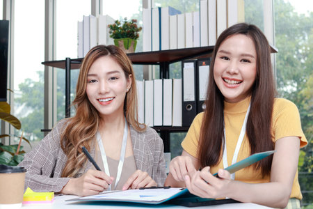 two business women sitting in the office Smile and enjoy working. Work on finance and marketing projects. Entrepreneurial concept.の写真素材