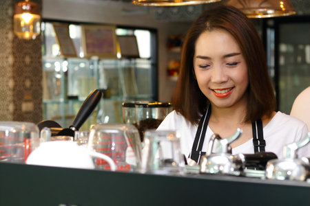 Beautiful Asian woman making coffee for customers. Coffee shop concept. Small Business, SME, Entrepreneur, Professional Baristaの写真素材
