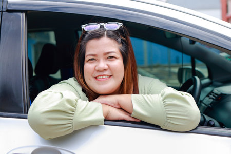 Asian fat woman smiling brightly drive a car Happy holidays. Tourism concept. Transportation, traveling by car. insuranceの写真素材