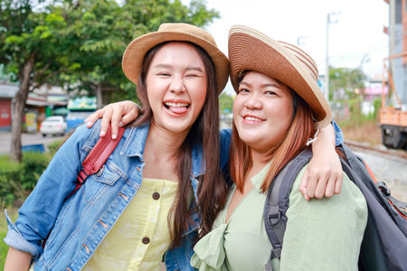 Portrait of two young Asian women hugging their necks happily traveling by train. Tourism concept. Traveling by train in Thailand. outdoor adventure travelの写真素材
