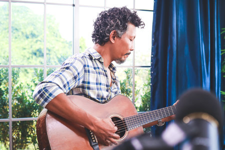 Asian male musicians enjoy playing acoustic guitars. International musical instruments of the type of stringed instruments. Bands and live music performances. music teacherの写真素材