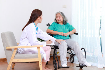 Asian female doctor treats an elderly patient sitting in a wheelchair. Internal Medicine Specialist Take care of the elderly. Hospital medical servicesの写真素材