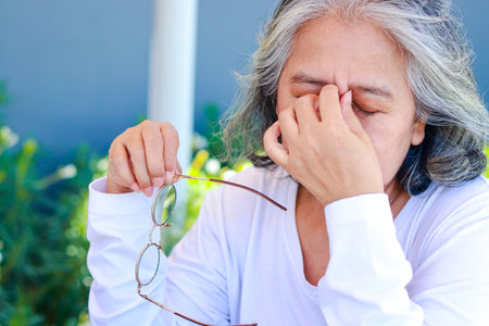 Asian elderly women have vision problems. Have eye pain. Eye disease in the elderly. cataracts, diabetic retinopathyの写真素材