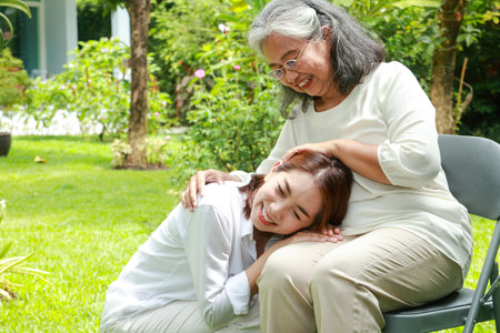 Asian family concept. Woman caring for elderly mother at home sitting and talking in the gardenの写真素材