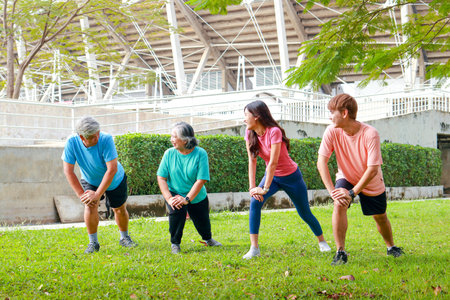 Group of people of various ages exercising outdoors in the morning. They smile happily. Sport concept, fitness family, health care.の写真素材