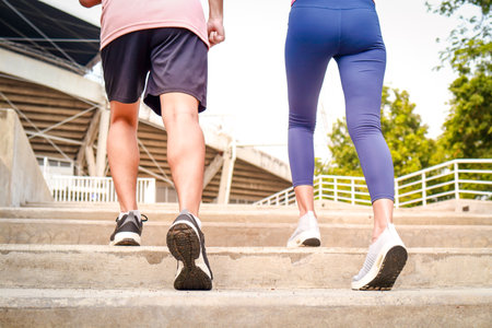Two young couples in sportswear Run up the stairs for an outdoor workout early in the day. Female athletes and male athletes. Sports concept. Exercise for a healthy lifestyle.の写真素材