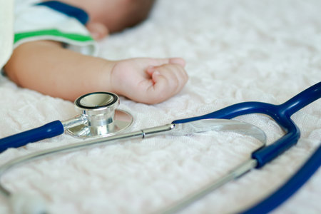 A stethoscope is placed on a bed near a male infant. Baby health care concept. disease of young childrenの写真素材