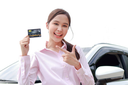 Beautiful Asian woman office worker getting a new car Holding a credit card, she smiles happily. Cash card concept. car insuranceの写真素材