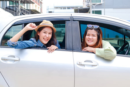 two asian women Are driving a car to travel. Travel concept. Transportation Travel by private car. Outdoor adventure travel. car insuranceの写真素材