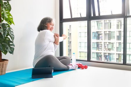 Asian senior woman exercising in apartment. Sport concept, senior health careの写真素材
