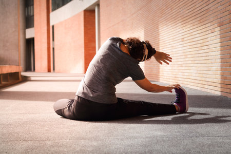 Asian woman exercising in the morning sitting stretching Before and after exercising on concrete...