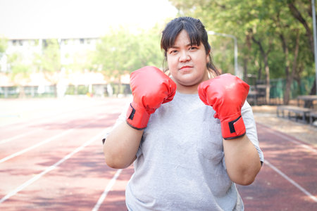 Fat Asian woman wearing red boxing gloves doing morning exercises. sports conceptの写真素材