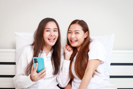 Happy smiling Asian lesbian couple lying on the bed in the bedroom. LGBT gender diversityの写真素材