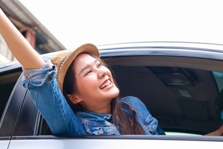 beautiful asian woman driving on a road trip happy smile. Tourism concept. Transportation, travel by private car. Outdoor adventure travel. car insuranceの写真素材