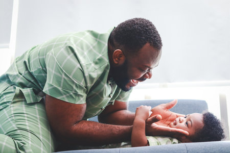 Father and baby playing together on the sofa in the living room at home. family conceptの写真素材