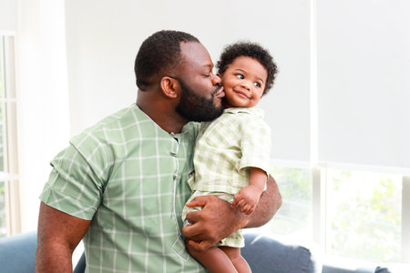 Portrait of a happy African American father and son in the house. Family concept.の写真素材