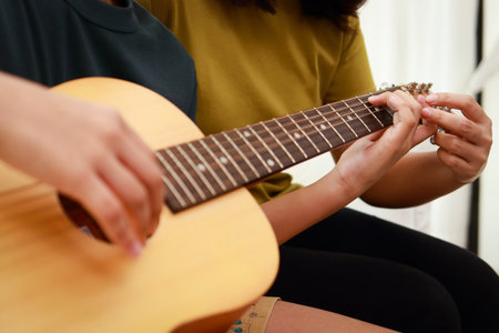 Asian boy learning music playing acoustic guitar with teacher. Classical band. music education