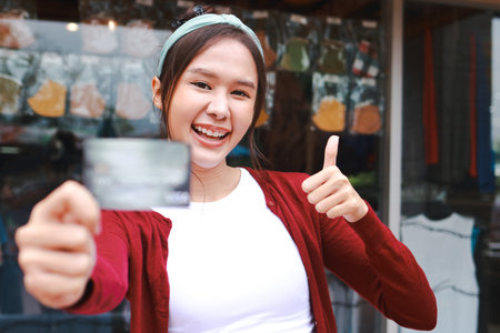 Pretty happy asian woman holding credit card for shopping. Business concept.の写真素材