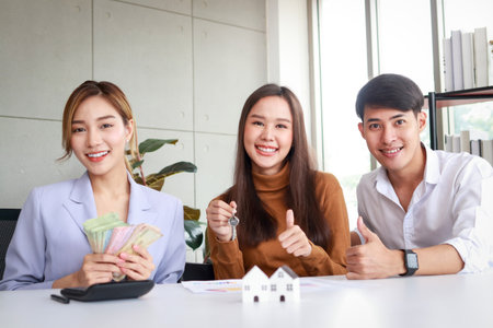 Asian couple buying a house with a real estate agent. Family concept. Moving to a new home or renting propertyの写真素材