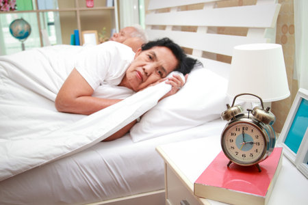 tribal elderly women Asian lying on the bed in the bedroom She can't sleep. senior health care conceptの写真素材